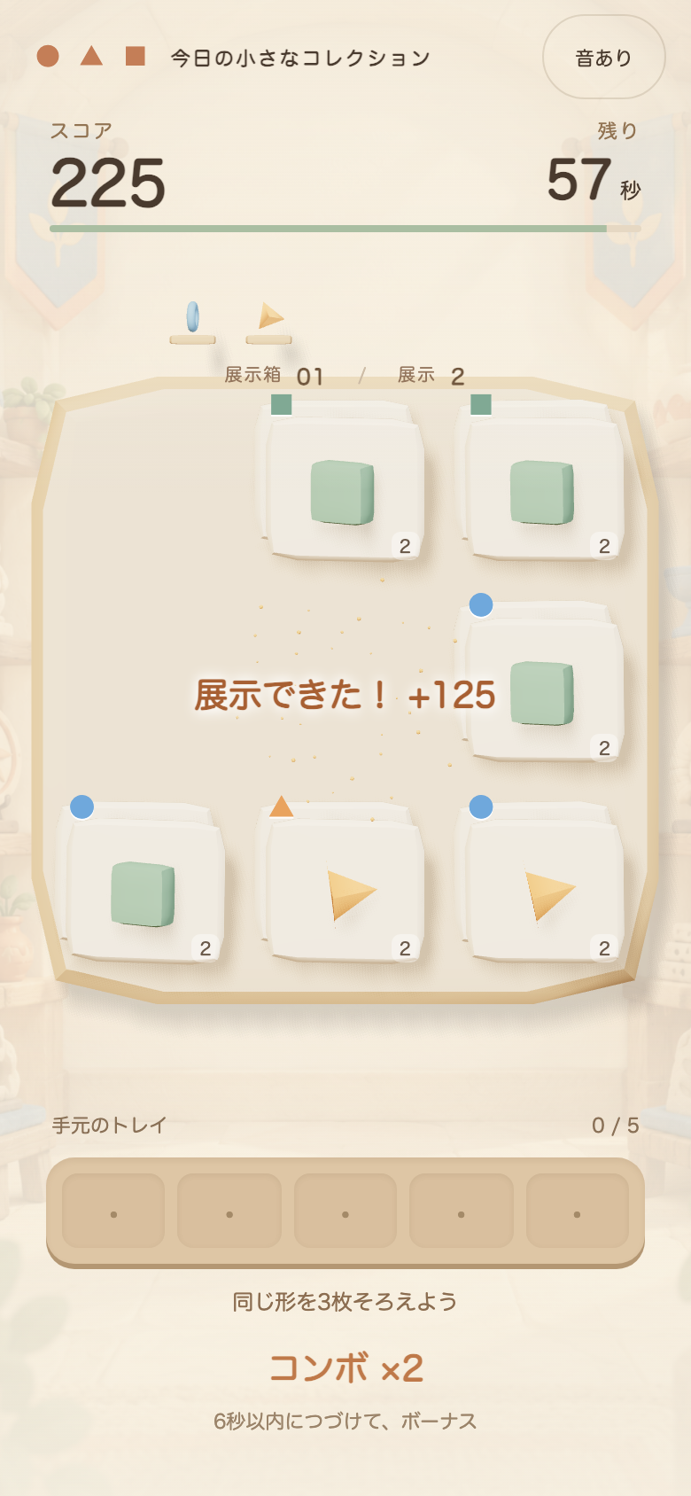 みつごの小さな博物館のプレイ中の画面。展示ケースの手前の札と、その奥に少しずれて見える札の形に注目すると次の一手が読める